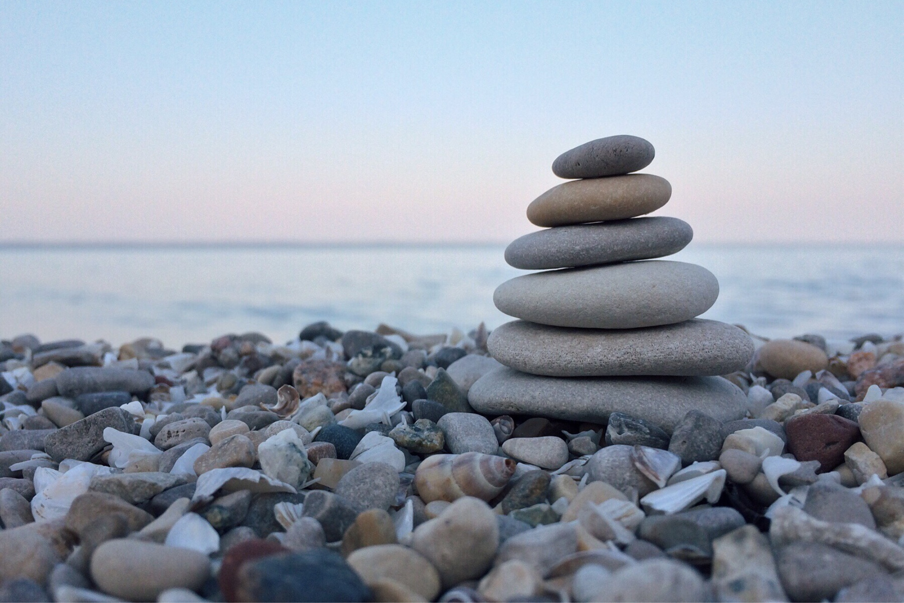 OxbowFountadtion-faith multi-colored river rock stacked along a shore